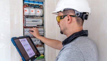 Photo d'un électricien qui change un tableau électrique pour