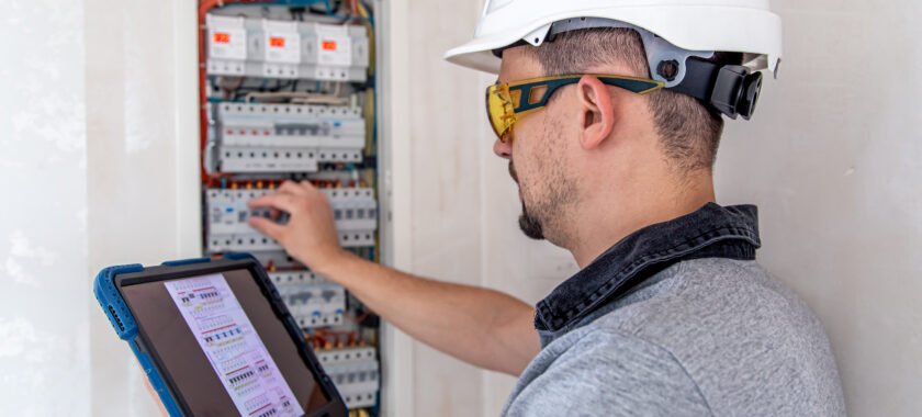 Photo d'un électricien qui change un tableau électrique pour