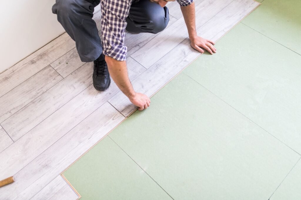 Photo d'un artisan posant du plancher sur un isolant